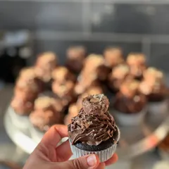 Holding up one of our Ferrero Nutella cupcakes to show off all the delicious details, from the creamy piping to the crunchy hazelnut topping.