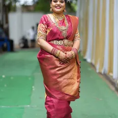A full-length view showing how the traditional jewellery complements the entire bridal ensemble. The layered necklaces and vaddanam create a beautiful silhouette.