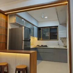 An open-concept kitchen featuring a breakfast counter that connects it to the living area. The grey and wood-finish cabinets create a sophisticated look, perfect for modern homes.