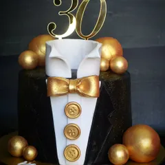 A sharp-looking tuxedo cake for a 30th birthday. The design features a crisp fondant shirt, bow tie, and jacket, perfect for a formal celebration.