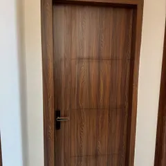 A simple yet elegant flush door with a dark wood laminate finish. The clean lines and modern black handle are perfect for a contemporary home.