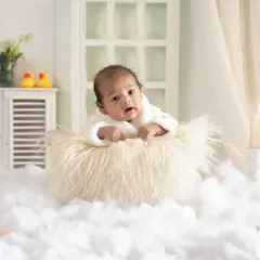 This little one is wide awake and ready for business in our 'Boss Baby' setup. Dressed in a tiny white bathrobe, he looks right at home on a cloud of fluff.