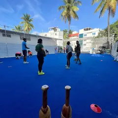 A group trains on our bright blue turf under a clear sky. This image showcases our vibrant, open-air training environment, a refreshing alternative to a typical gym.