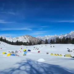 A vibrant campsite against a vast, snowy landscape. Winter camping requires a different level of physical and mental preparedness. I help you build the resilience to not just survive but thrive in cold, high-altitude environments.