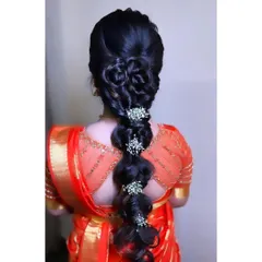 This is a modern take on a bridal braid. I created an intricate, multi-layered braid with bubble and floral details, finished with delicate baby's breath accessories for a unique and sophisticated look.