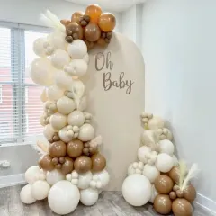 A chic and modern "Oh Baby" shower setup. The neutral-toned balloon garland with shades of brown and cream, accented with pampas grass, creates a sophisticated and trendy boho vibe.