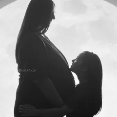 A powerful and creative black and white silhouette. This image tells a story of a growing family, with an older sibling looking up at her mother's baby bump against a full moon backdrop, symbolizing the new light coming into their lives.