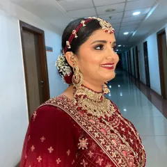 A side profile of a classic bridal look, showing the beautiful matha patti and how the makeup enhances her features from every angle.
