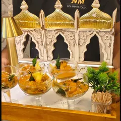 Our flying buffet service in action. A professionally dressed server presents individually portioned appetizers in elegant glassware, showcasing our commitment to both presentation and impeccable service.