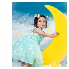 This portrait captures a happy moment from another celestial-themed shoot. The soft lighting and dreamy clouds create a magical atmosphere for this first birthday photo.