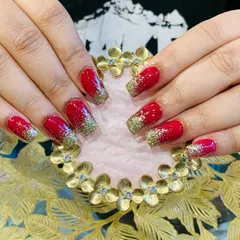 A festive and bold look with bright red nails and a heavy gold glitter gradient on the tips.
