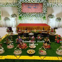 A full platter arrangement I created for an ear piercing ceremony in Coimbatore. The display includes a variety of decorated plates featuring dolls, fresh fruits, and flowers, all set up beautifully at the Arunai Arangam Mandapam.