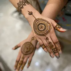 A minimalist mandala design, perfect for someone who wants a touch of henna without full coverage. The central mandala is connected to the finger with a delicate chain of dots.