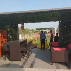We can create inviting outdoor rooms using artificial greenery. Here, we've covered the walls and ceiling of a patio structure with faux ivy, defining a cozy and private seating area in an open yard.