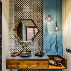 This powder room makes a bold statement with geometric patterned tiles and a vibrant blue accent wall. The hexagonal mirror and unique vessel sink add to the eclectic and stylish design.