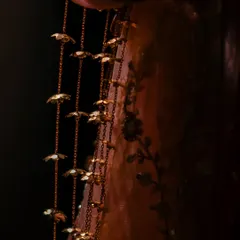 A macro shot of the delicate 'kaleerein' hanging from the bride's bangles, a beautiful and significant part of the bridal attire.