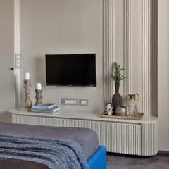 For this client who wanted a calm room, I used simple textures on the wall and a monochromatic palette. The fluted paneling on the TV unit and wall adds visual play without being overwhelming.