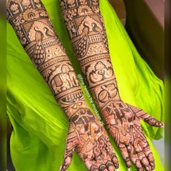 A grand design for a grand day. This full-arm bridal henna includes everything from couple portraits and wedding rings to peacocks and elephants, telling a complete story.