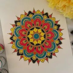 This ornate mandala is filled with rich, jewel-toned colors like deep pink, teal, and yellow, all outlined in gold. The complexity of the pattern combined with the vibrant colors makes it a truly luxurious piece of art.