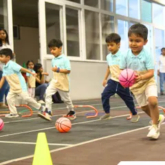Little athletes participate in a dribbling race, showing their developing motor skills and competitive spirit.