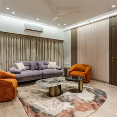 Another view of the living area, highlighting the seamless wall paneling that conceals doors and storage. This minimalist approach ensures the focus remains on the curated furniture and luxurious textures.