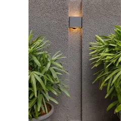 An exploration of intentional design, where a simple wall light creates a play of light and shadow on a textured surface. This detail demonstrates how material selection and careful execution cultivate an elevated spatial experience.