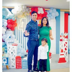 A happy family portrait at a Paw Patrol party. The backdrop features a vibrant balloon arch and character-themed props, creating a perfect photo opportunity.