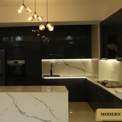 This is a modern kitchen I designed for a client who loves bold contrasts. It features sleek, black high-gloss cabinetry paired with a striking white marble-patterned island and backsplash, all illuminated by statement pendant lighting and under-cabinet LEDs.