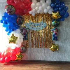 It's-a me, Mario. This Super Mario themed birthday setup features a vibrant balloon arch in classic red and blue, star balloons, and character cutouts, creating an immersive experience for the birthday boy and his friends.