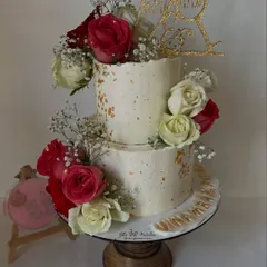 I designed this rustic two-tier cake specifically for a Roka ceremony, complete with a custom topper. The textured buttercream, gold dust speckles, and arrangement of fresh red and white roses create a chic and celebratory look.