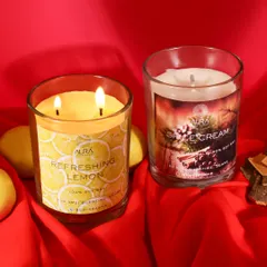 A bold and vibrant shot of lemon and spice scented candles against a rich red fabric. This composition is warm and inviting, perfect for highlighting festive or winter-themed fragrances.