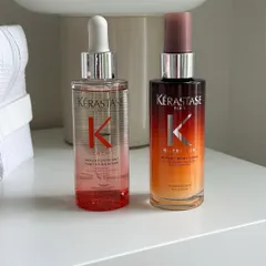 A clean, aesthetic shot of Kérastase Genesis and Nutritive serums on a modern nightstand. We offer these luxury products for you to continue your hair care routine at home.