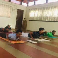Students holding Bhujangasana, or cobra pose, during a Yogasanas session. This posture is excellent for strengthening the spine, but precision is key. I guide everyone to engage their muscles correctly to build strength safely and effectively.