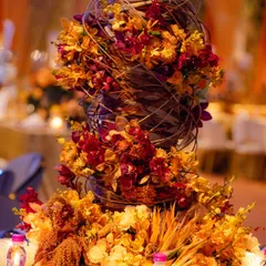 A closer view of the midollino arrangement, detailing how the delicate flowers are interwoven with the structured, wooden reeds. This technique creates a beautiful tension between natural softness and architectural form.