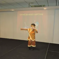 A student performs in a traditional costume, showcasing grace and focus. We celebrate diverse forms of expression and encourage children to connect with their cultural roots through performance.