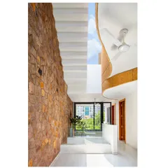 A large, curved skylight floods this double-height volume with natural light, while also directing rainwater into a storage tank, showcasing the fusion of aesthetic form and sustainable function.