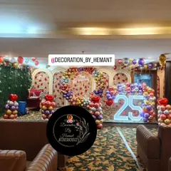 For a grand 25th wedding anniversary, I transformed this hall into a spectacular celebration space. The setup includes a large stage with multiple arches, a custom ring backdrop, and a lit marquee number, all tied together with a vibrant balloon arrangement.