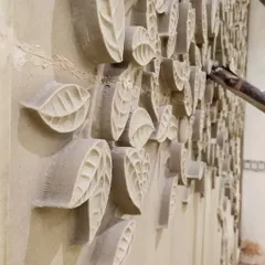 Here, our team is meticulously installing custom-carved sandstone panels on a double-height wall. This shows our focus on using natural materials and intricate craftsmanship to create unique, textured accent walls.