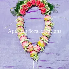 This beautiful garland is made from pink lotus buds, accented with baby's breath and a crown of green ferns. It's a popular choice for both weddings and deity worship.