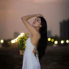 I love shooting outdoors during the golden hour. For this beach portrait, we used the soft, warm sunset light to create a serene and dreamy mood, highlighting the model's peaceful expression against the city lights.
