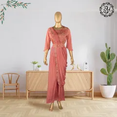 This hand-stitched georgette drape dress in a soft peach hue is both elegant and modern. The delicate embroidery and matching belt create a flattering silhouette, perfect for any celebration.