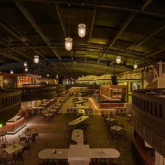 Another perspective of the expansive layout, highlighting the interplay between the upper and lower levels. The design uses curved balconies and strategically placed bars to guide movement and create a dynamic flow throughout the venue.