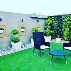 A modern terrace design combining artificial turf, a vertical garden wall, and comfortable seating. I also install decorative elements like pebble borders and wall mounted planters.