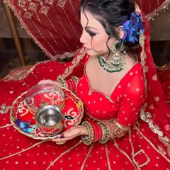 A side profile of the Karwa Chauth look, showing the elegant hairstyle with blue flowers and the detailed green beaded necklace.