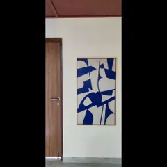 A single, bold abstract painting can transform a simple corner. This piece uses a striking cobalt blue and off-white composition to create a powerful pop of color against a neutral wall.