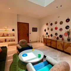 We designed this playful and inspiring room around custom armchairs and a central coffee table. The space is filled with personality, from the colorful furniture and unique wall decor to the curated collection of art toys on illuminated shelves.