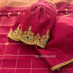 A magenta velvet blouse with puffed sleeves and a heavily embroidered cuff featuring green stones. The texture of the velvet adds depth and richness to the color.