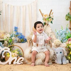 A full view of the blue and cream boho setup. The teepee, jute rug, and elephant plushie come together to create a whimsical and stylish scene for a first birthday.