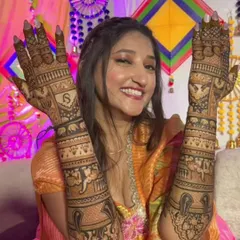 A happy client showing her full-arm bridal mehendi. The design includes personalized elements and traditional motifs, all done with my natural henna for a dark, beautiful stain.