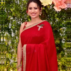 A candid portrait of a guest at a family celebration. Her bright smile and radiant red saree add to the vibrant and festive atmosphere of the event, which we love to capture.
